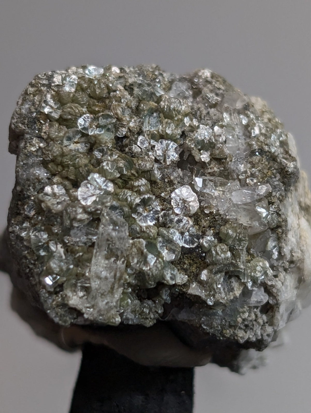 A rough, irregularly shaped mineral specimen featuring translucent, crystalline formations with a mix of clear and pale greenish hues embedded in a darker matrix.