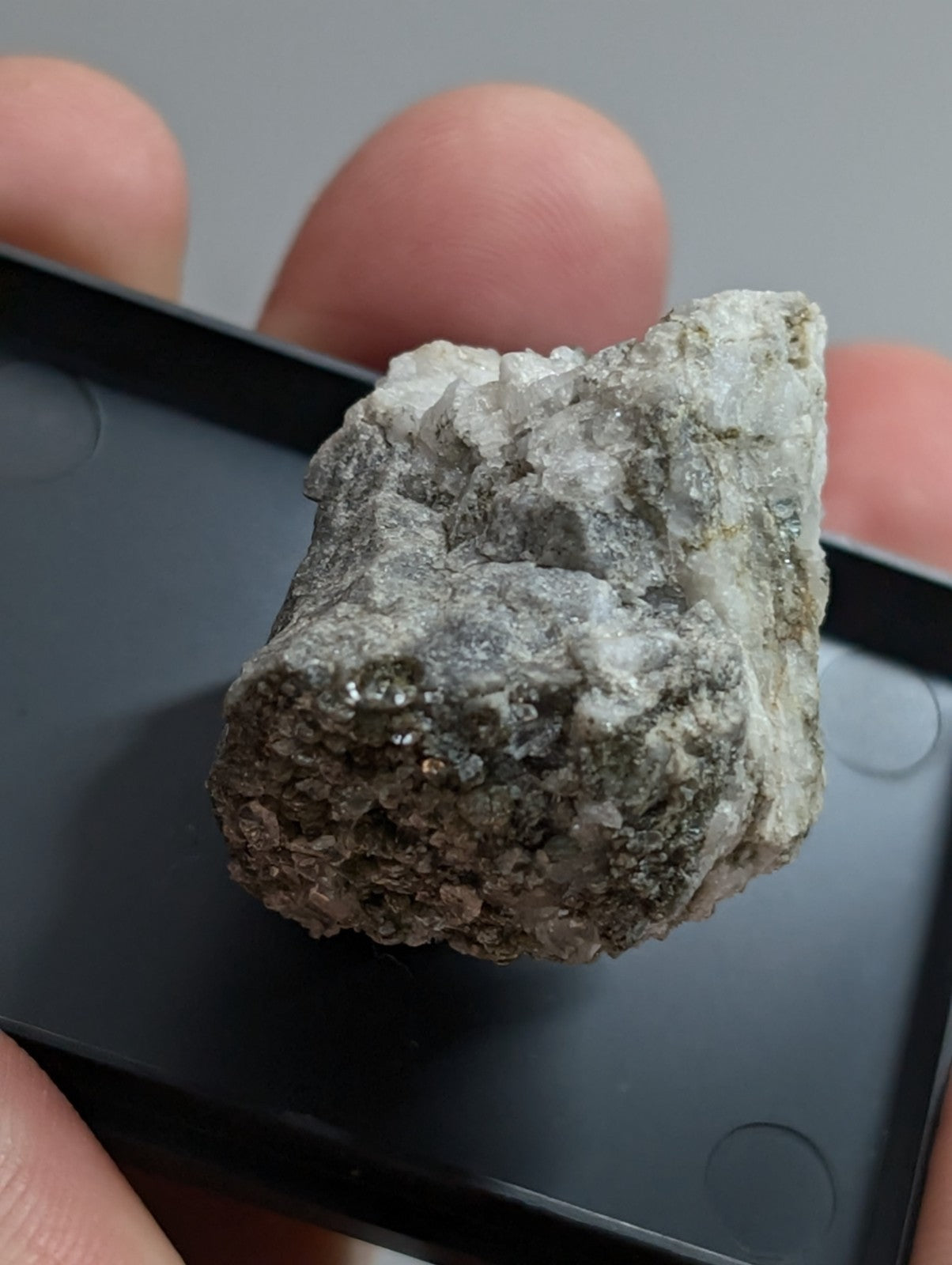 A rough, irregularly shaped mineral specimen with a mix of gray and white crystalline textures.