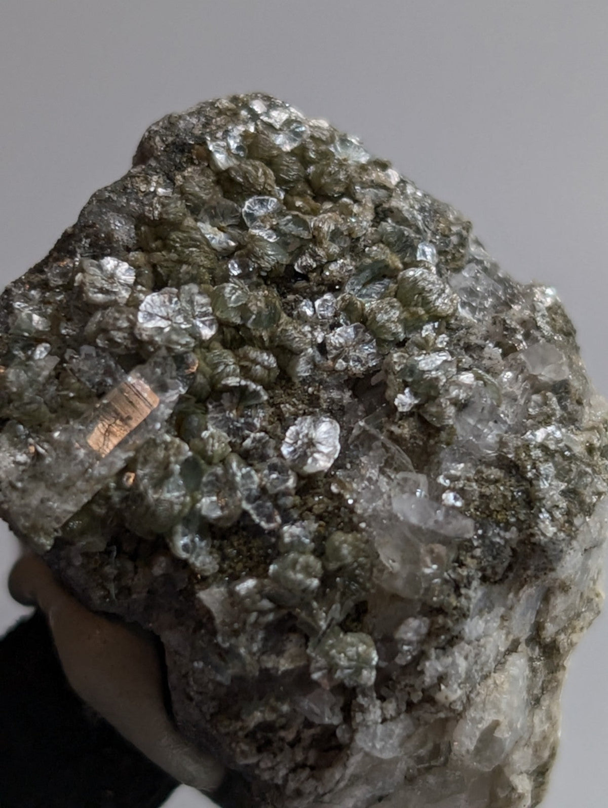 A rough, irregularly shaped mineral specimen featuring a dense cluster of translucent, crystalline formations with varying shades of clear and pale green.