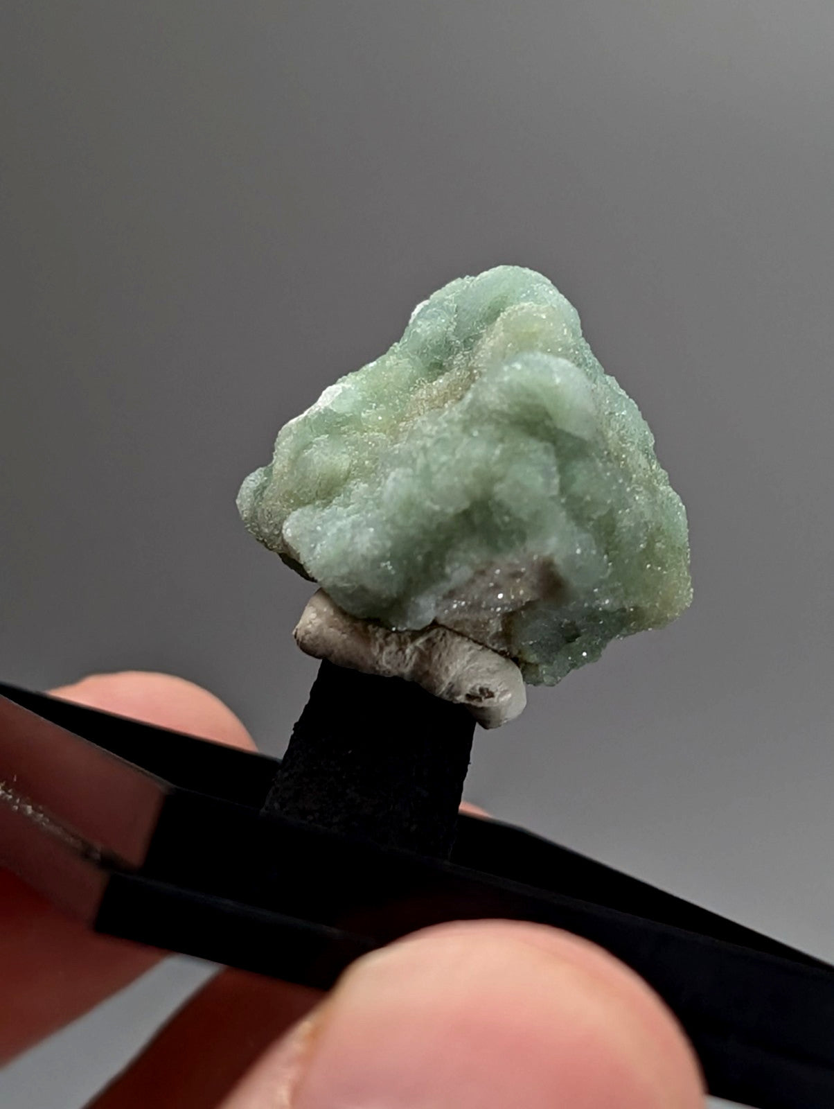 Green wavellite rough light green jade specimen with textured surface and mineral inclusions from Arkansas USA with case