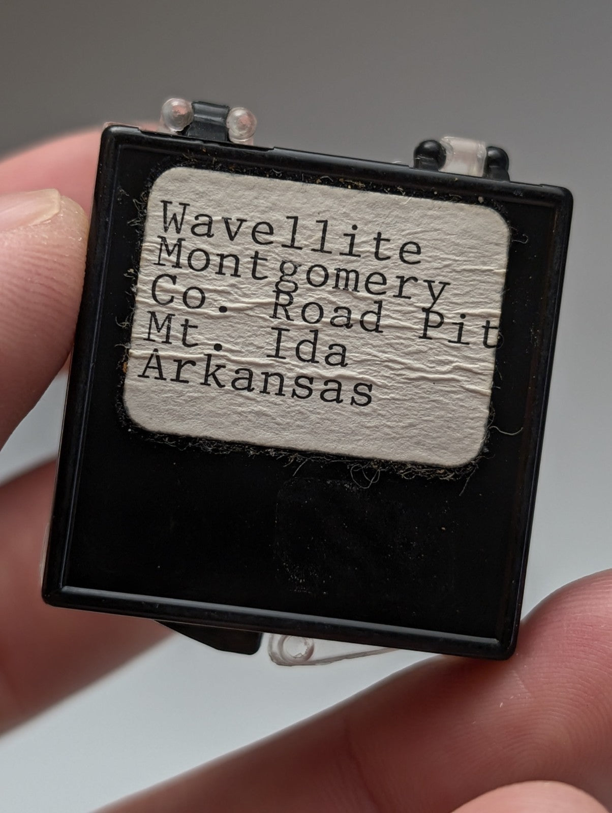 Black rectangular mineral specimen container with vintage paper label for green wavellite from mauldin mountain arkansas