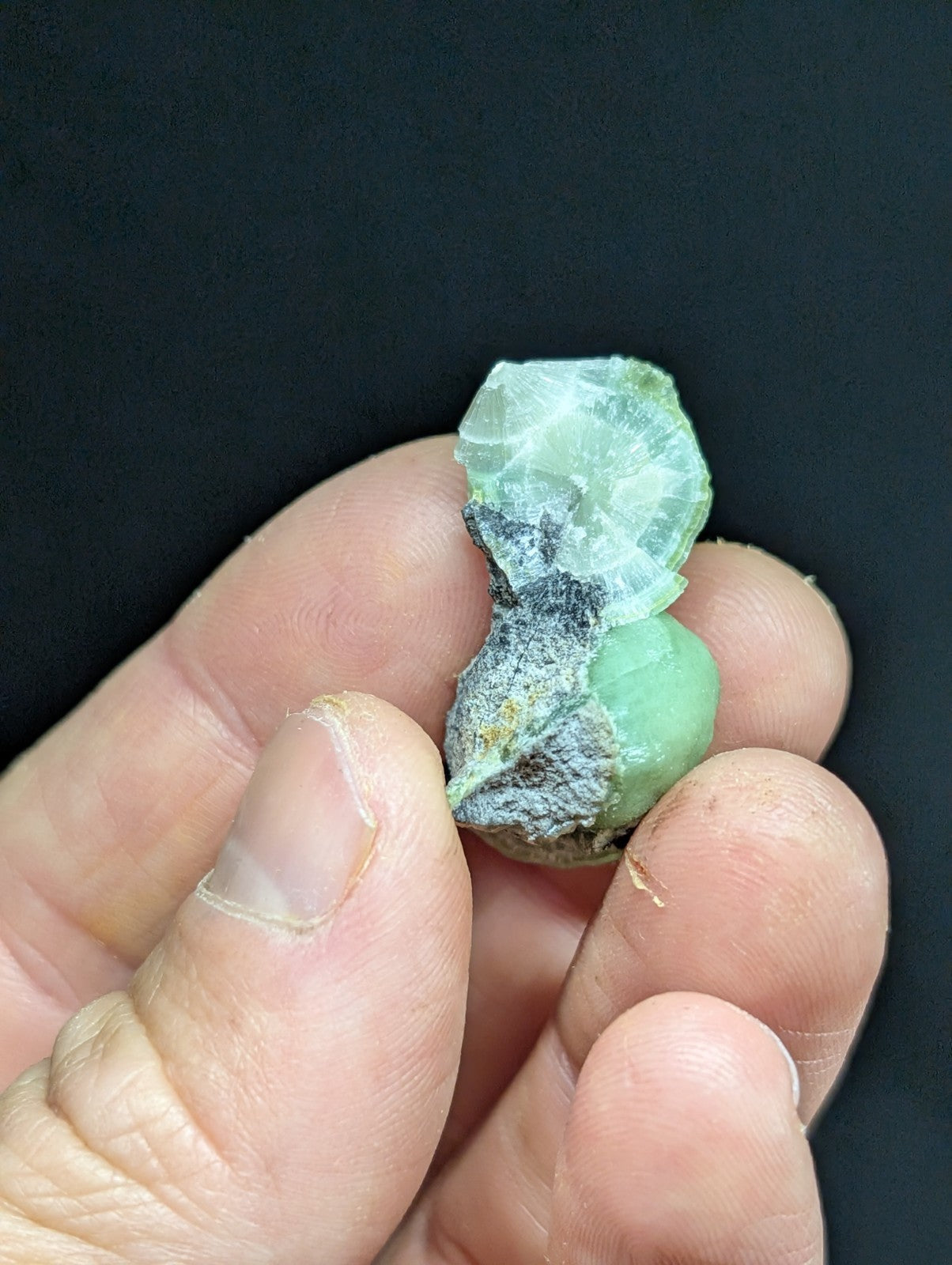 A rough, light green mineral specimen with a translucent quality and visible internal crystalline structure.