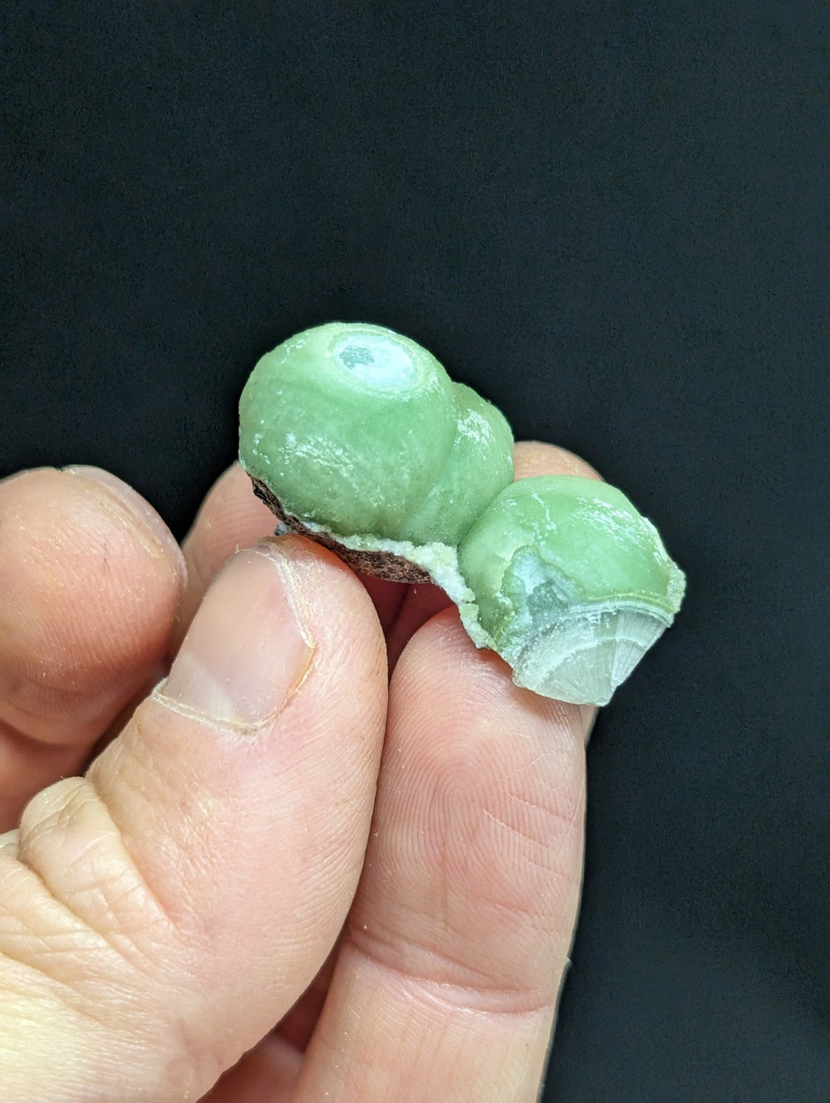 A pale green, translucent mineral specimen with a smooth, slightly glossy surface and visible internal crystalline structure.