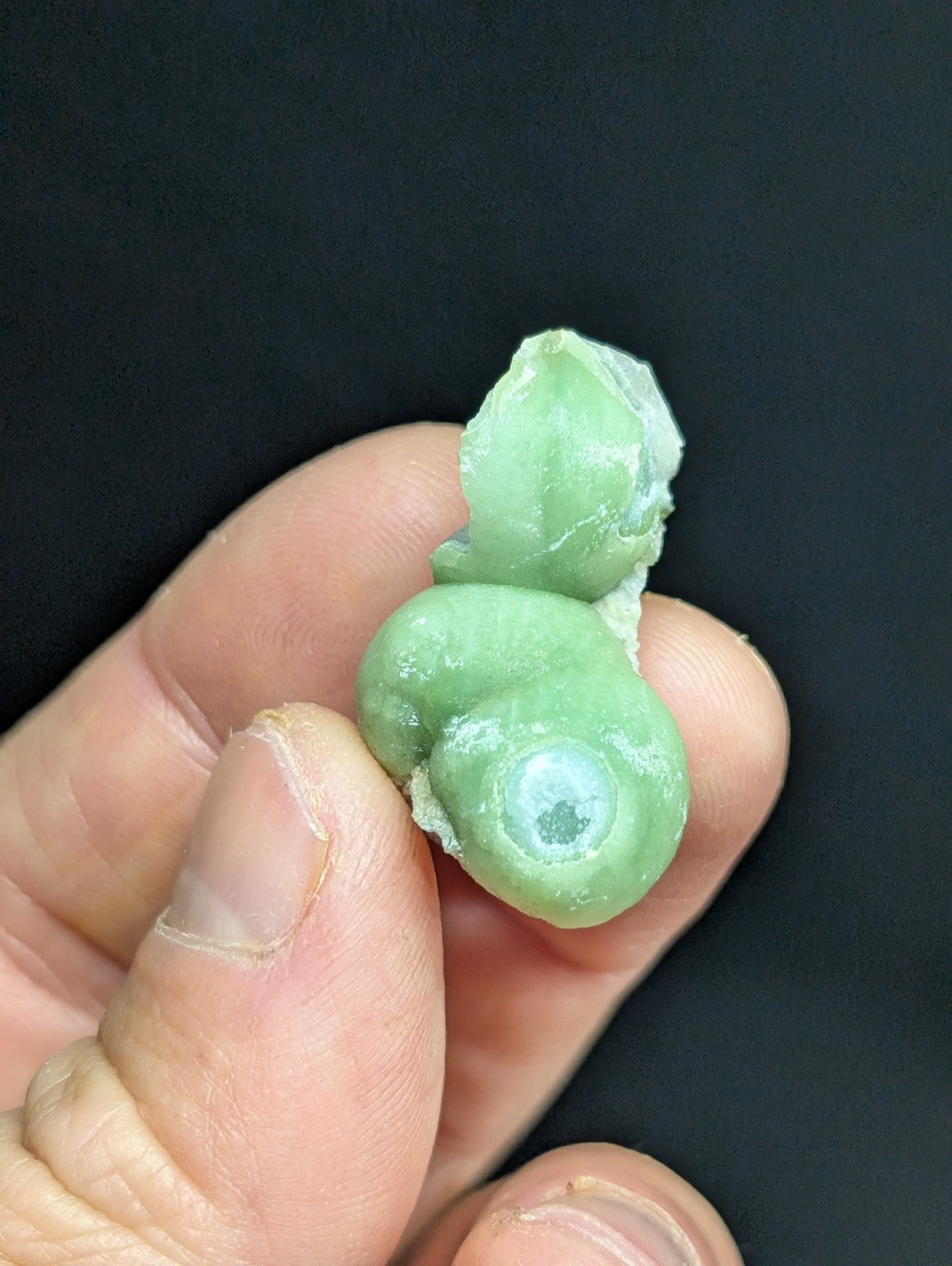 A smooth, light green jade figurine with a polished surface and natural stone texture.