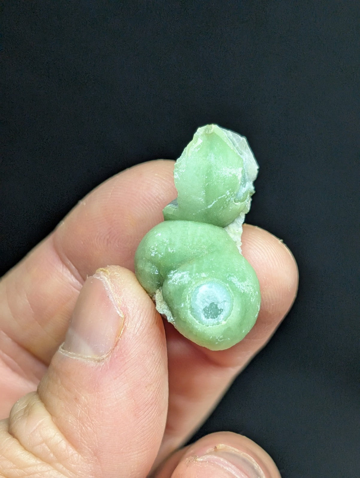 A smooth, light green jade figurine with a polished surface and natural stone texture.