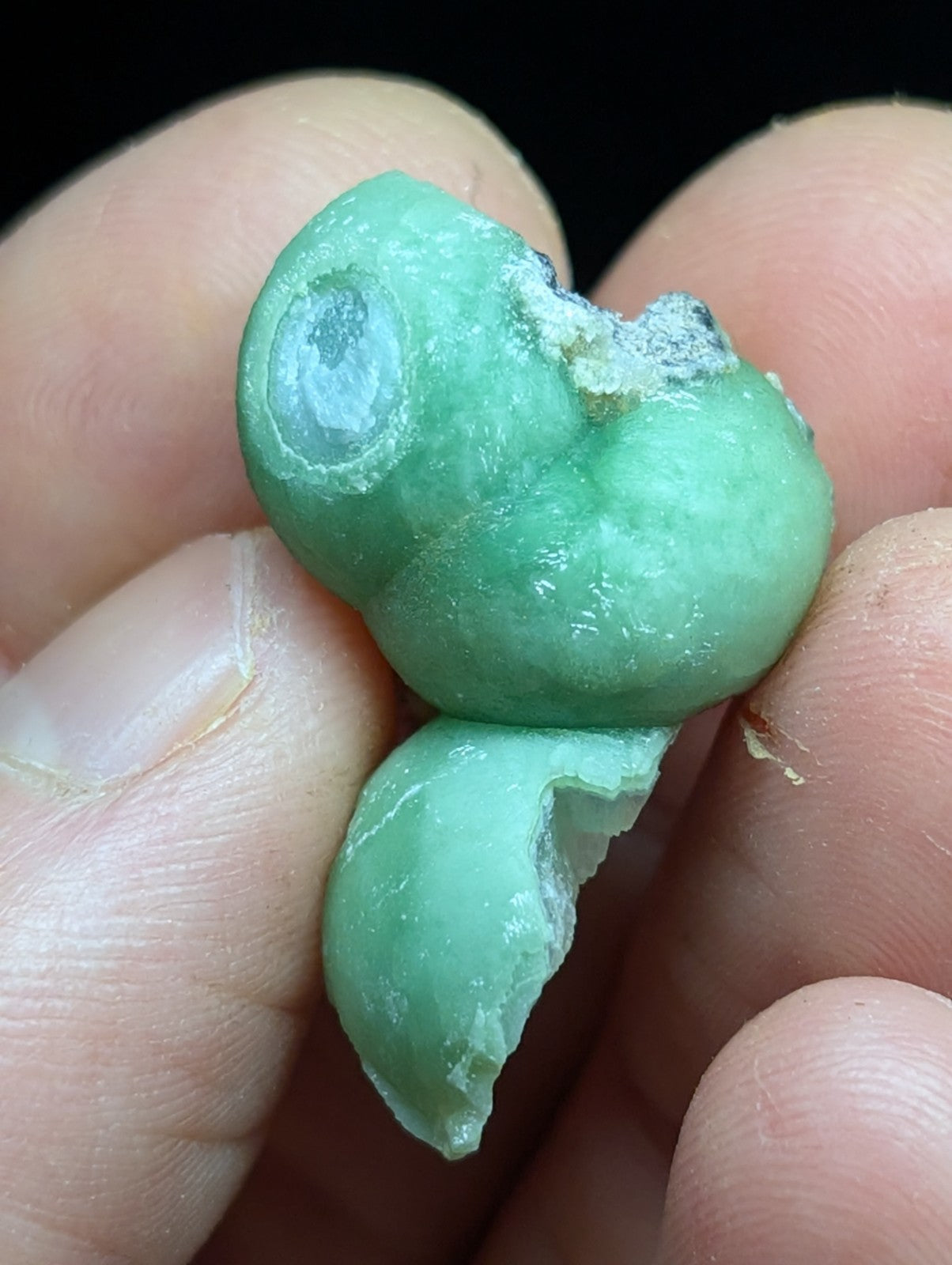 A smooth, light green jade-like stone with a slightly translucent quality and visible natural imperfections.