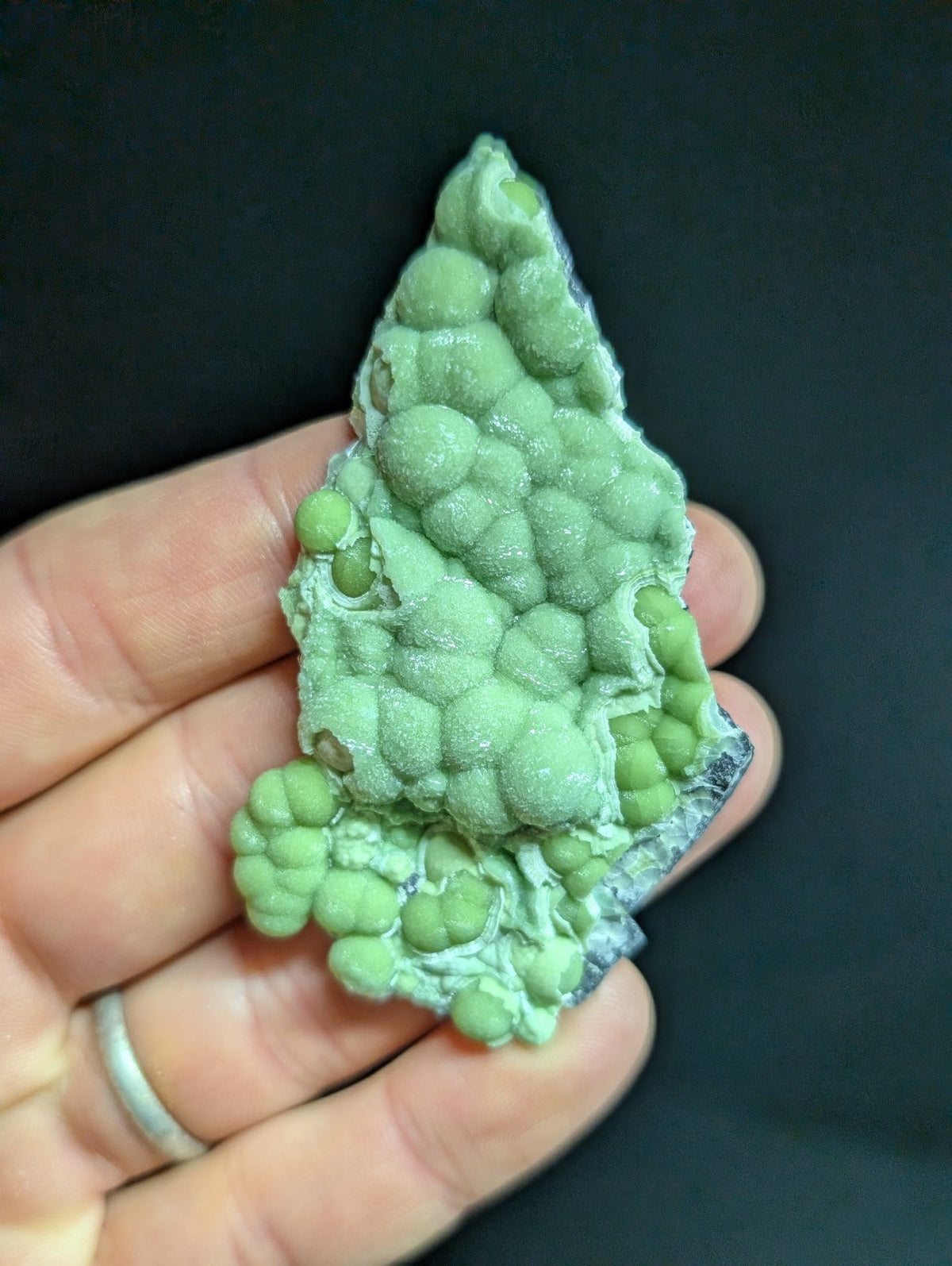 A light green, bumpy mineral specimen with rounded nodules and a rough, crystalline surface.