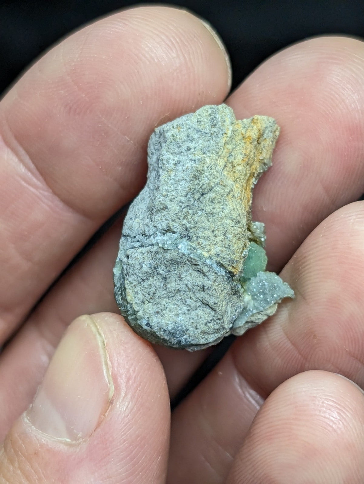A rough, irregularly shaped mineral specimen with a mottled green and yellowish surface.