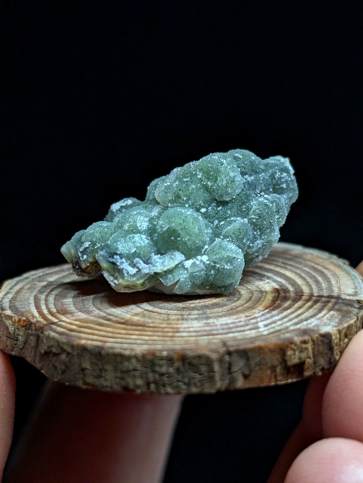 A translucent green mineral specimen with rounded, clustered formations and a slightly frosted surface.