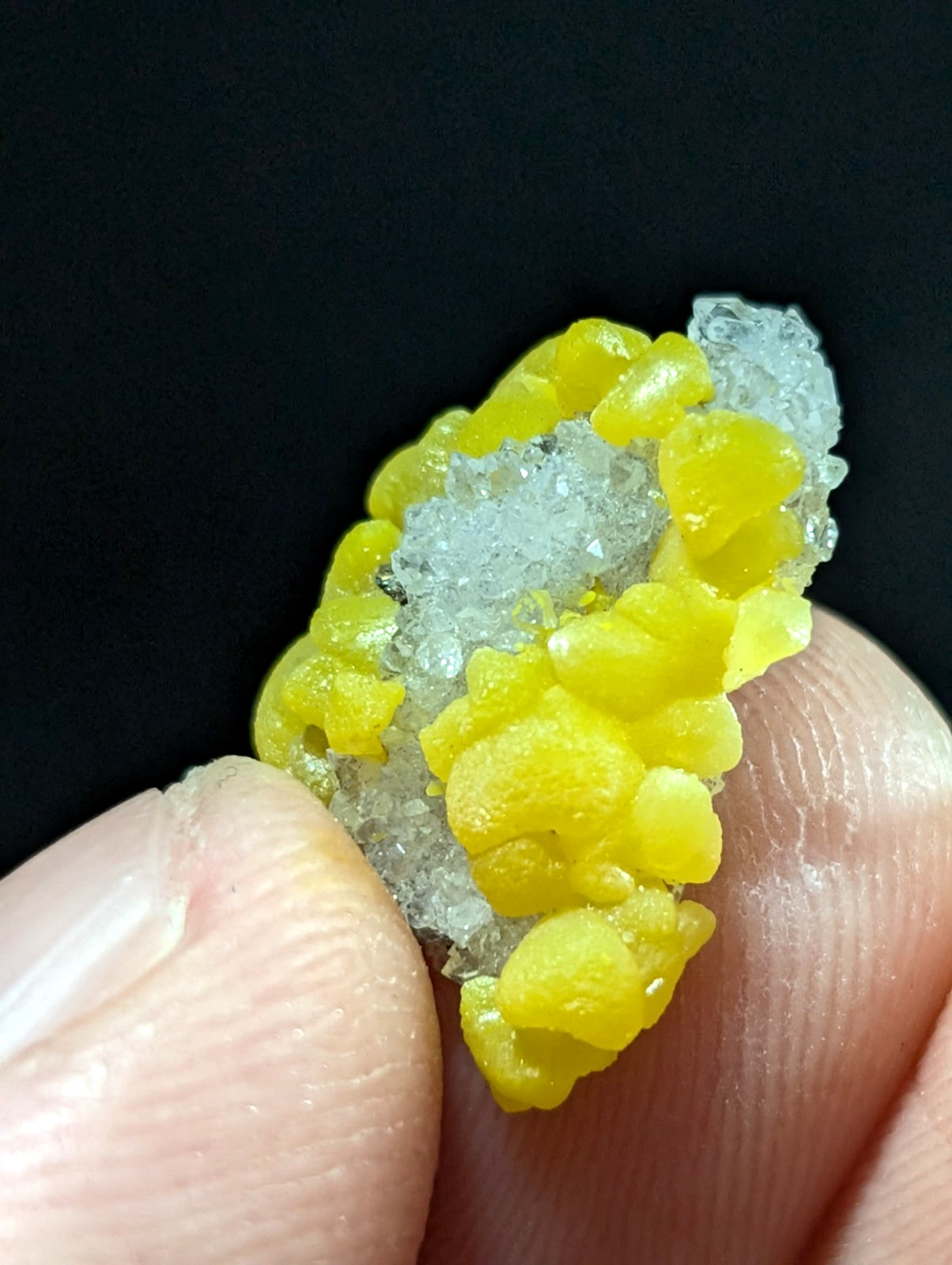 A vibrant yellow and translucent crystal cluster with a rough, organic texture.