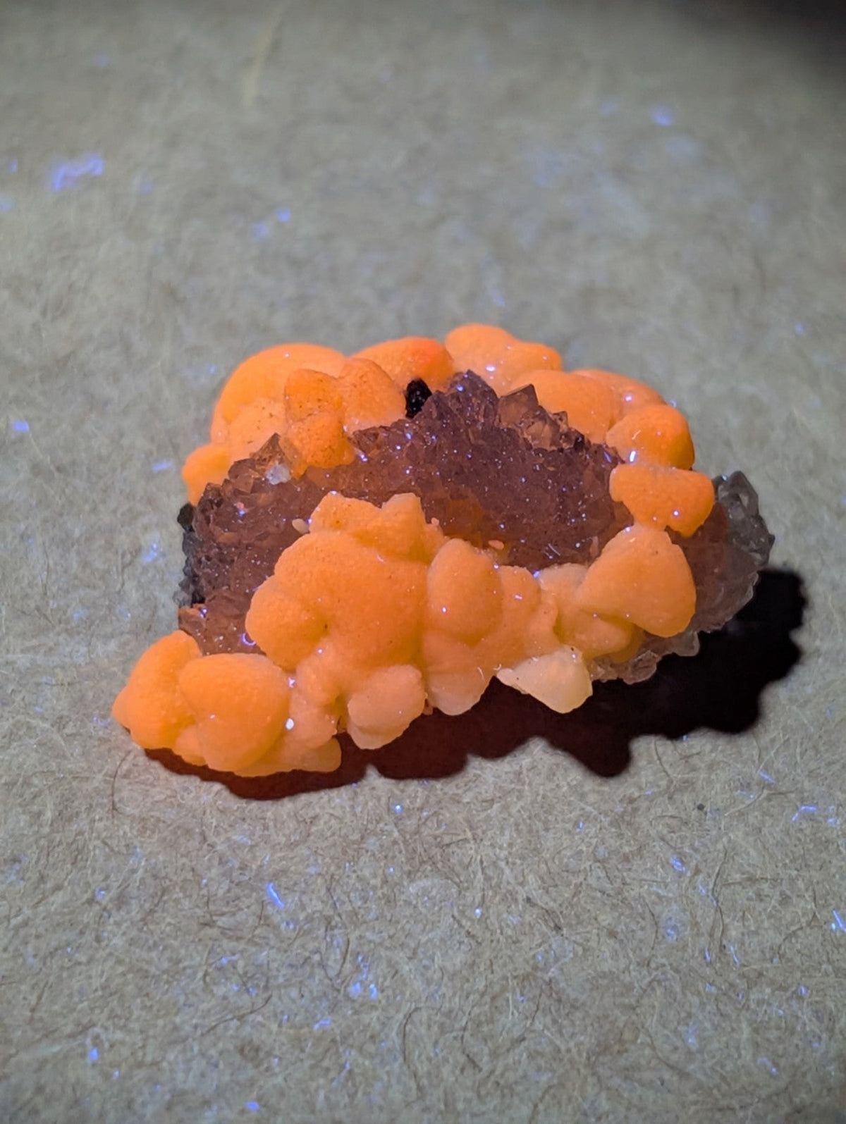 Vibrant orange, bubbly mineral formation with a crystalline base.