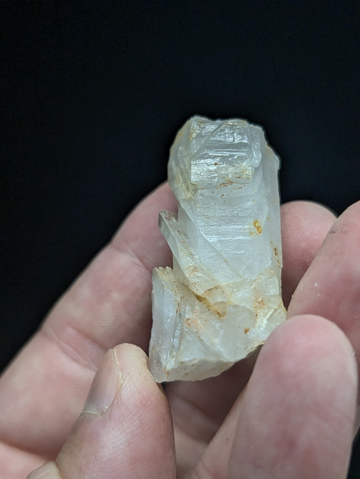 A translucent, pale quartz crystal with natural facets and subtle golden inclusions.
