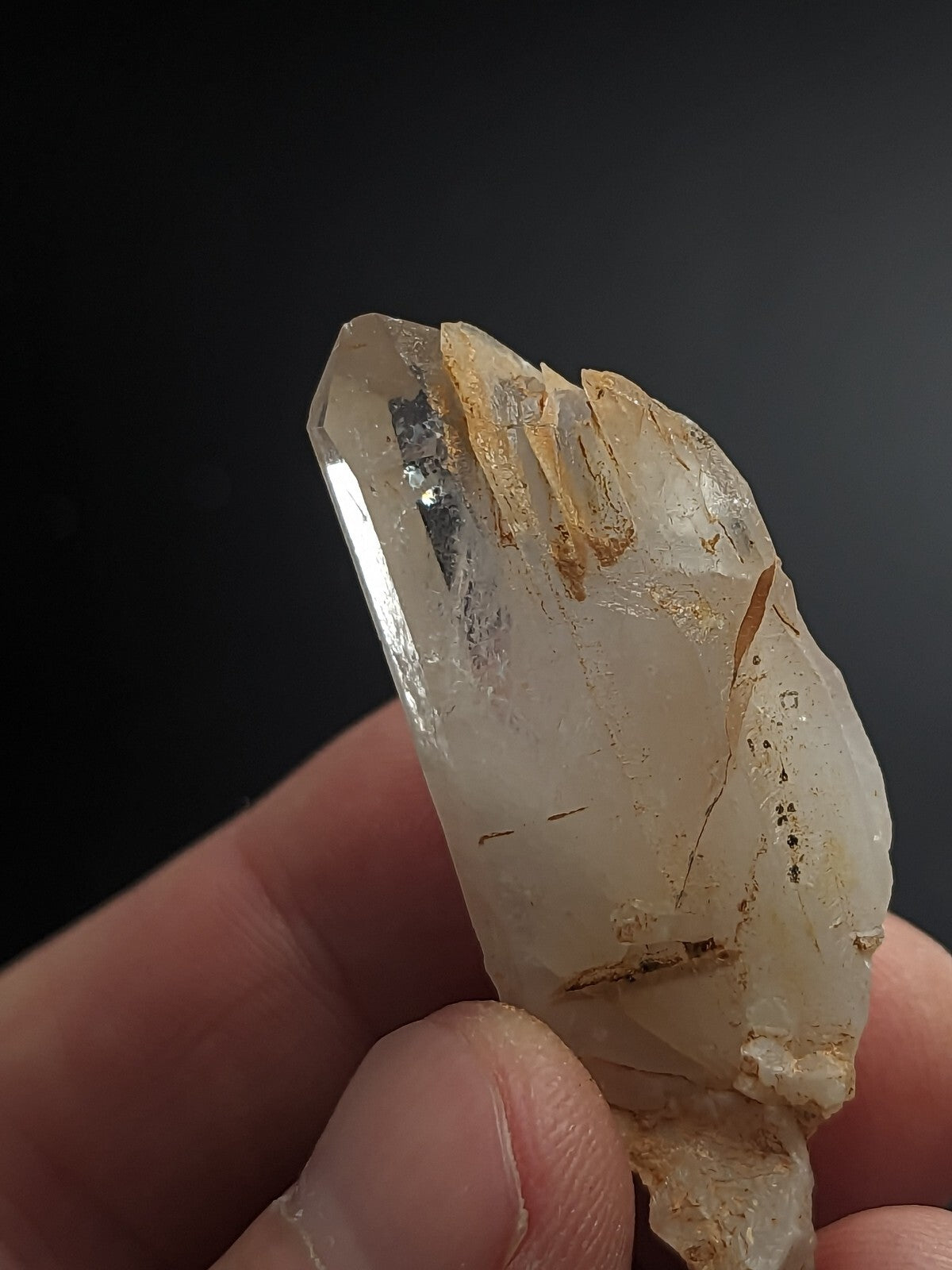 A translucent, pale quartz crystal with natural inclusions and a slightly rough, jagged surface.