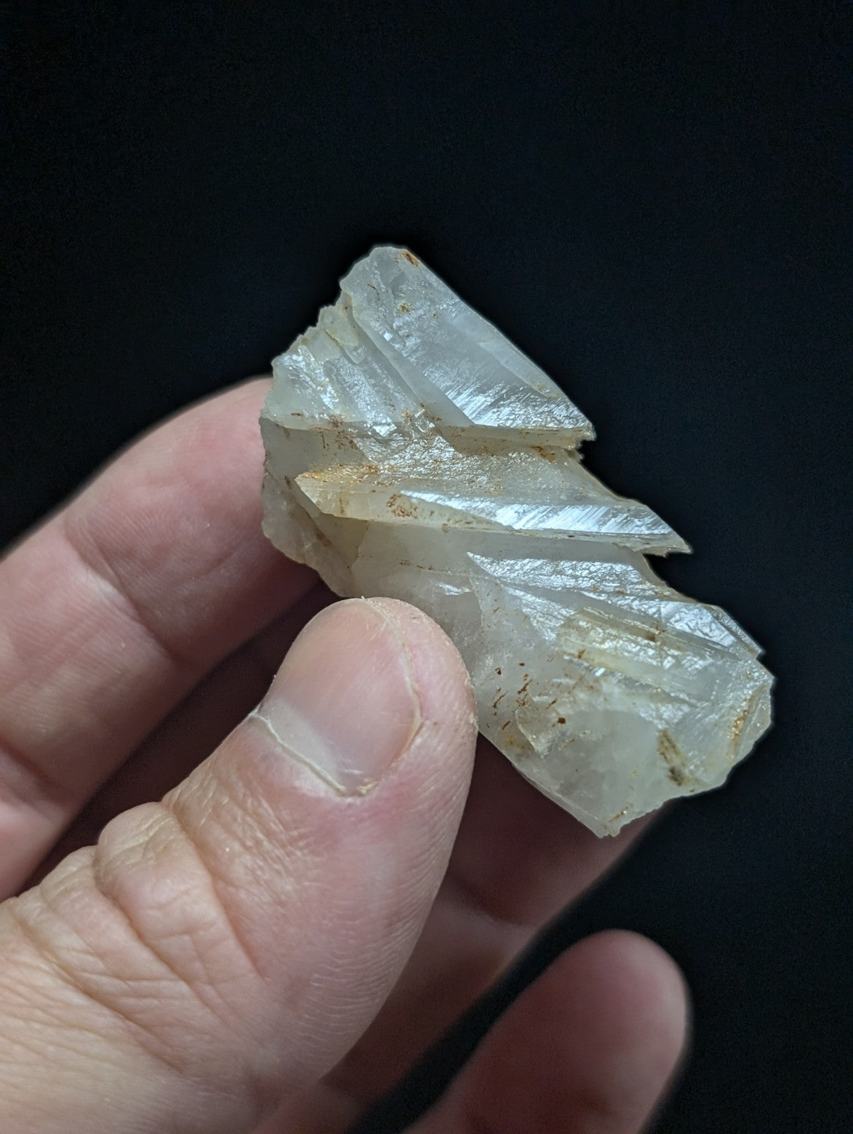 A translucent, pale white quartz crystal cluster with sharp, angular facets and subtle golden inclusions.