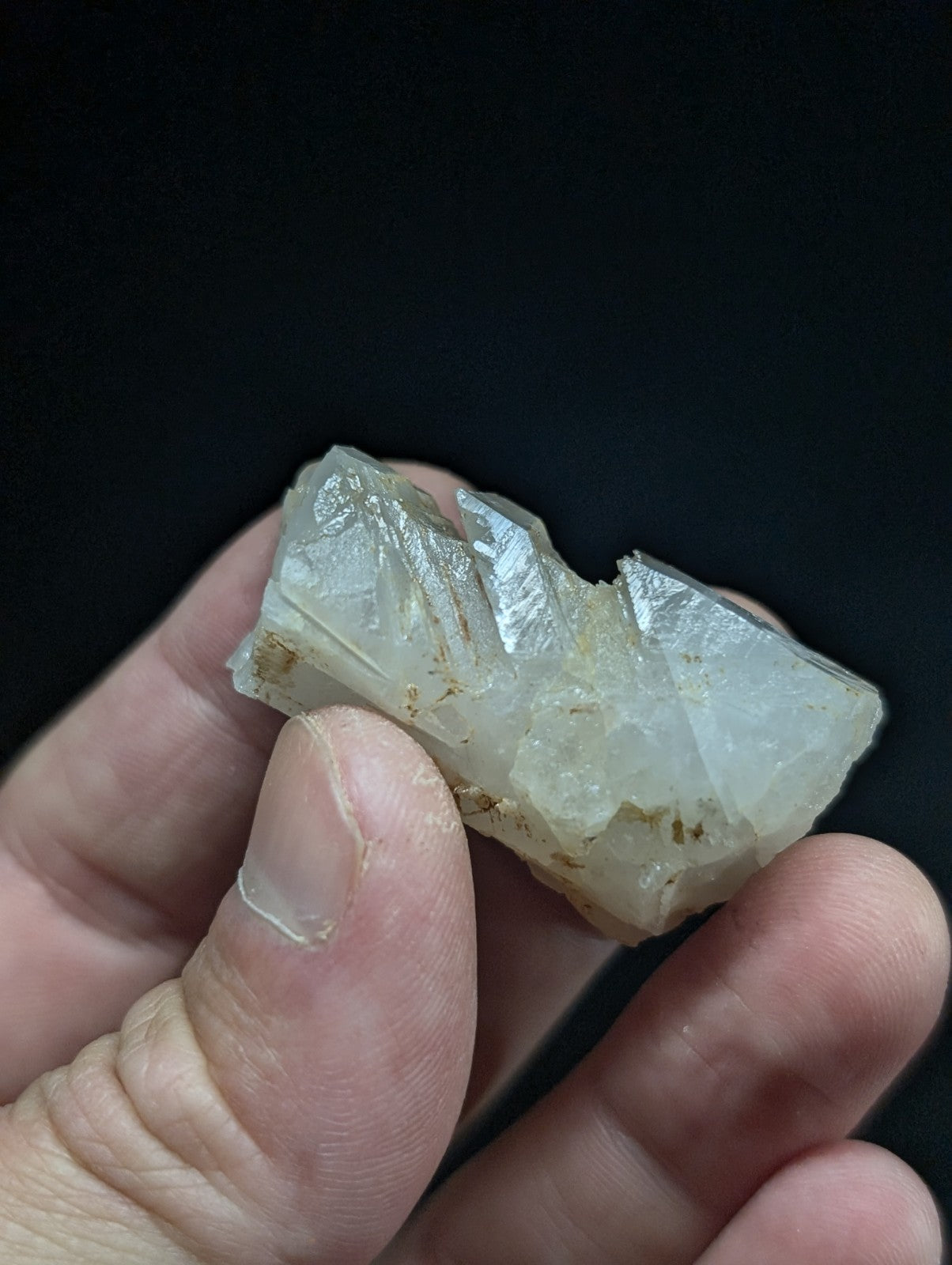 A translucent, pale white mineral specimen with visible crystalline facets and faint golden inclusions.