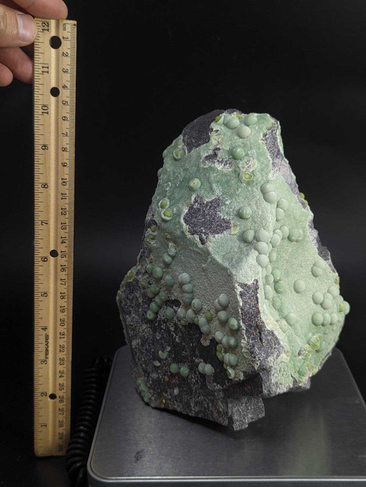 A green and gray mineral specimen featuring numerous small, rounded nodules across its surface.
