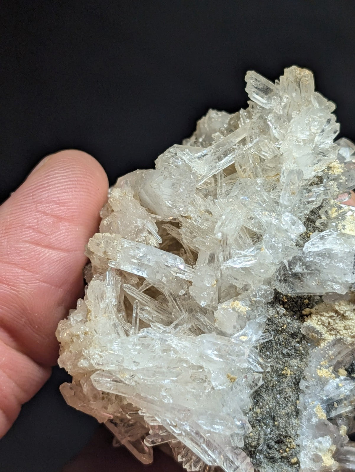 A cluster of clear, translucent quartz crystals with sharp edges and a slightly golden tint at the base.