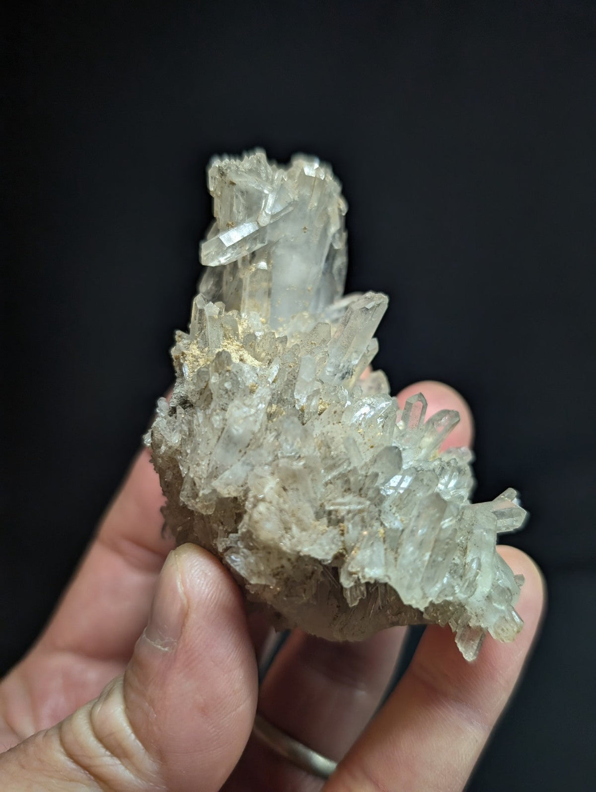 A translucent, crystalline quartz cluster with sharp, pointed facets and a pale, slightly cloudy appearance.