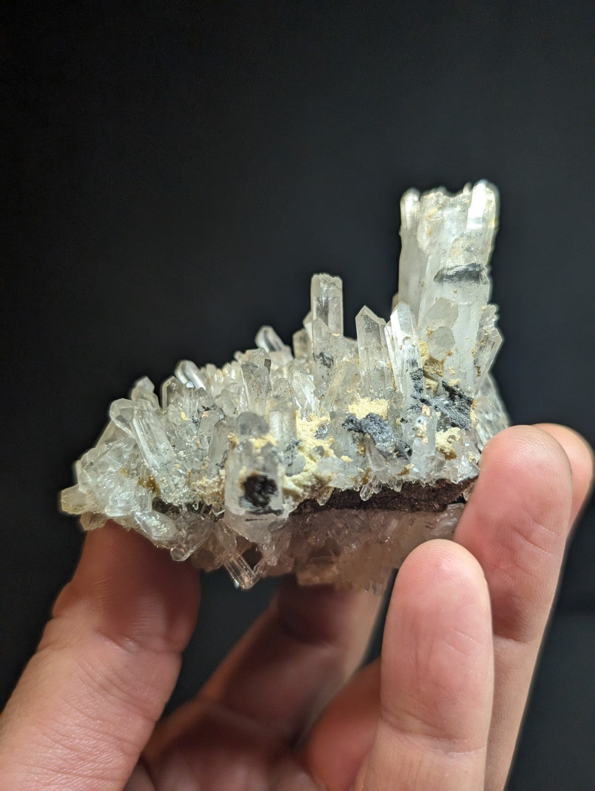 A translucent, crystalline mineral specimen with clear quartz-like formations and dark inclusions.