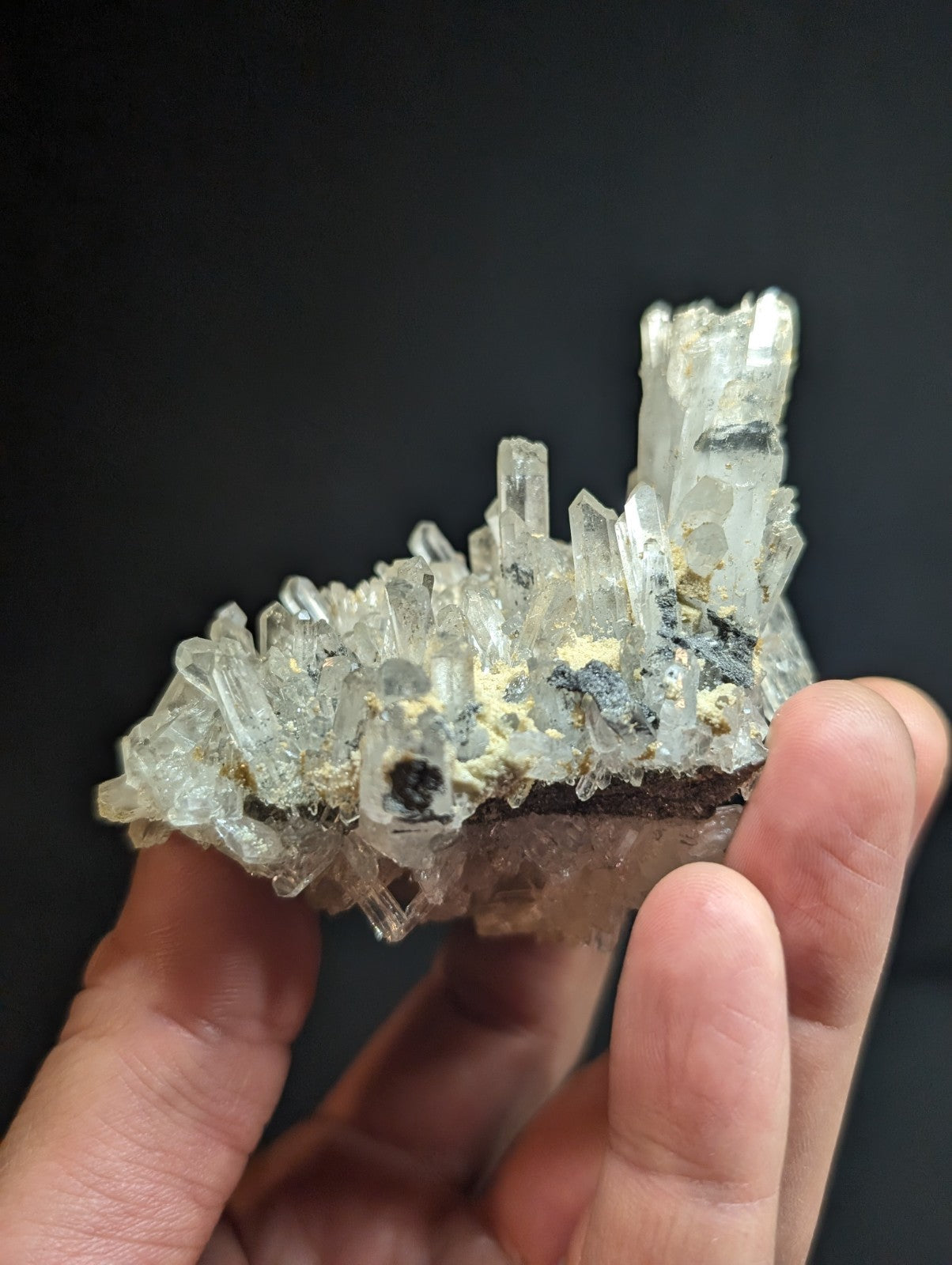 A translucent, crystalline mineral specimen with clear quartz-like formations and dark inclusions.