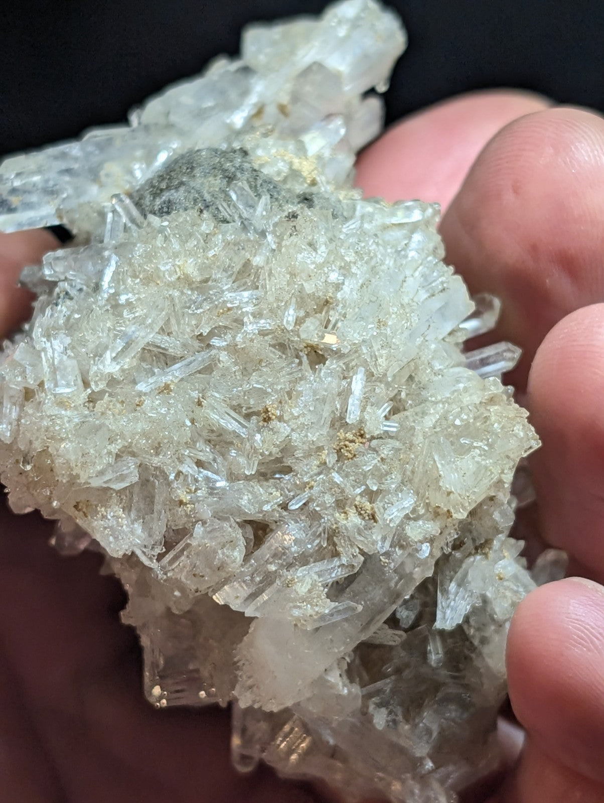 A cluster of translucent, clear quartz crystals with subtle golden inclusions and sharp, angular facets.