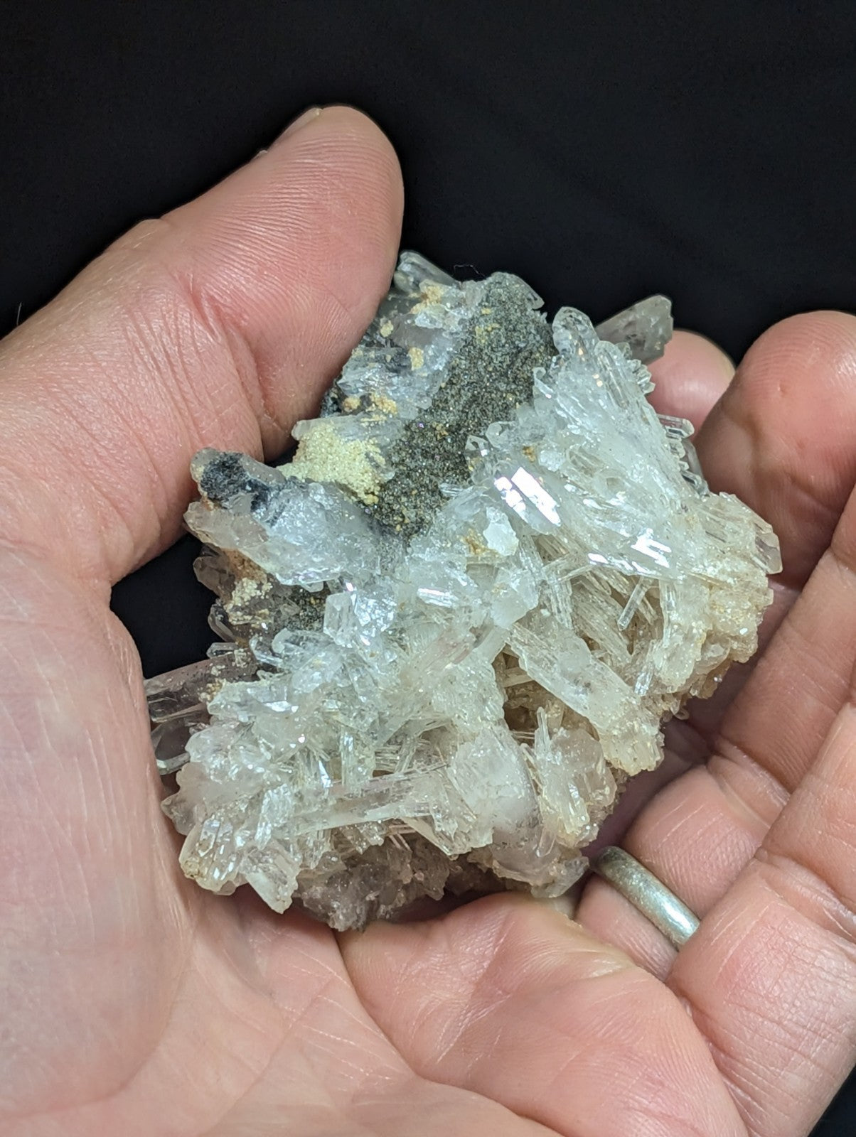 A translucent, crystalline mineral specimen with clear and pale greenish hues, featuring sharp facets and a natural, irregular cluster formation.