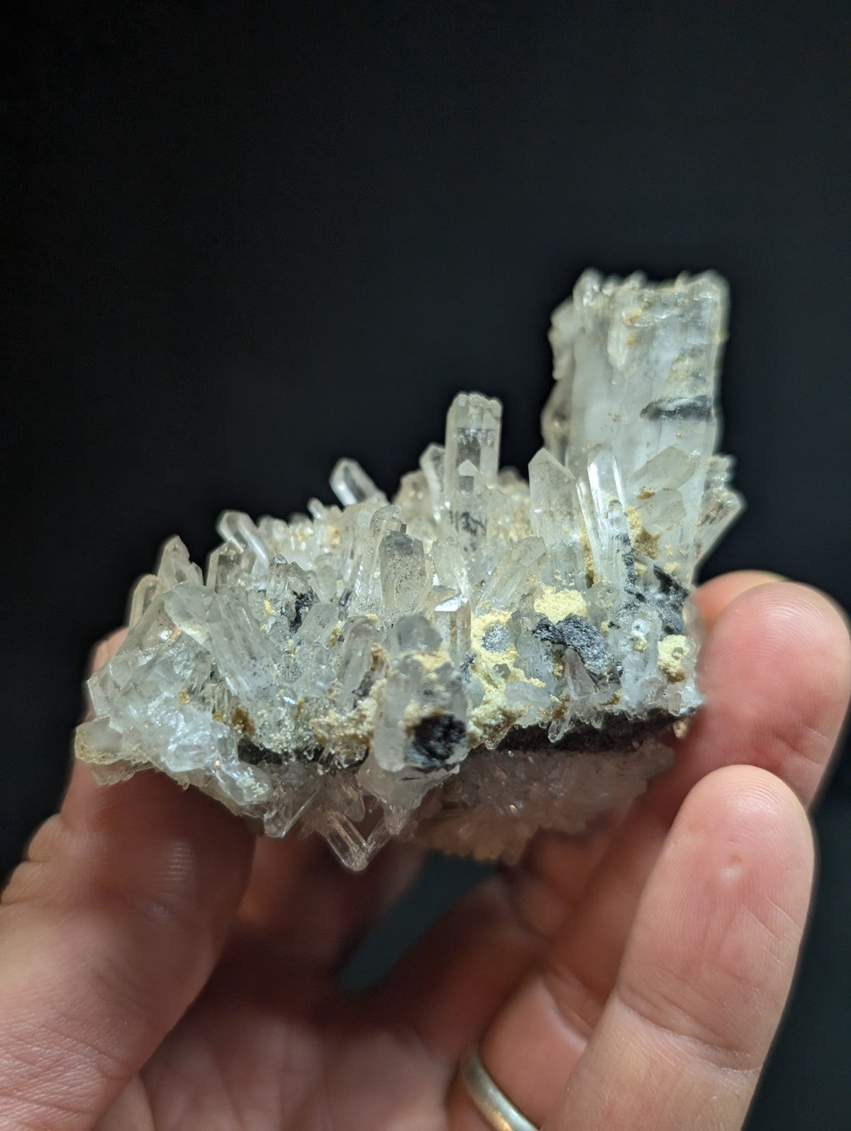 A translucent, crystalline mineral specimen with clear quartz formations and dark inclusions.