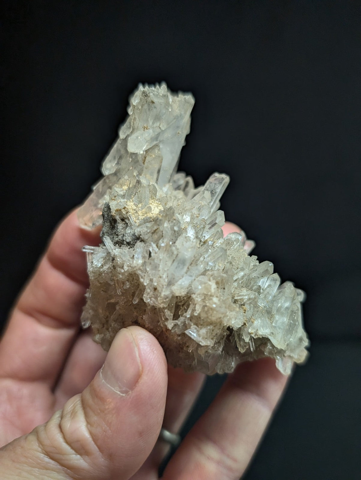 A translucent, crystalline quartz cluster with sharp, jagged edges and a mix of clear and slightly cloudy sections.