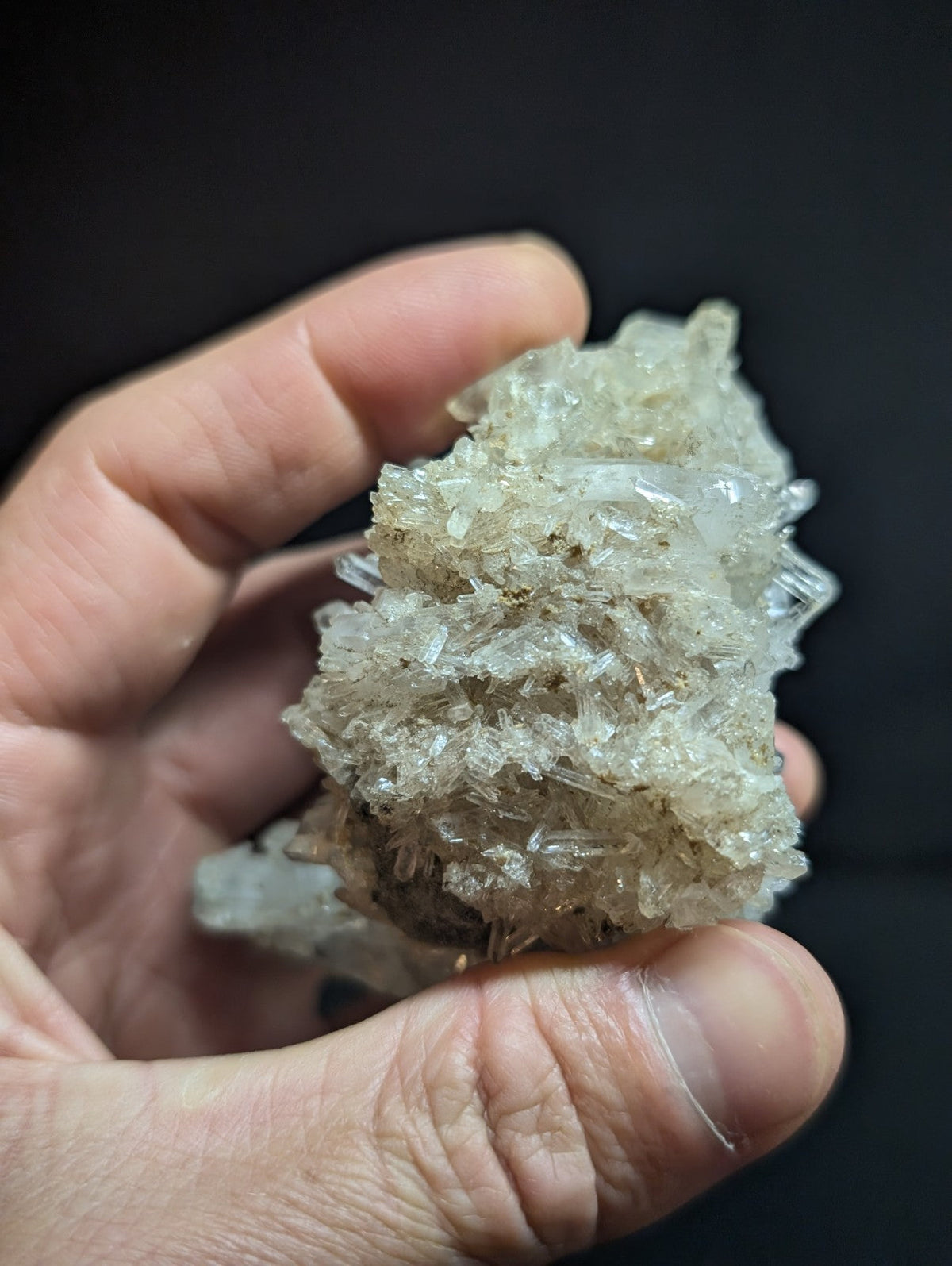A translucent, crystalline mineral specimen with a rough, jagged surface and subtle brownish tint.