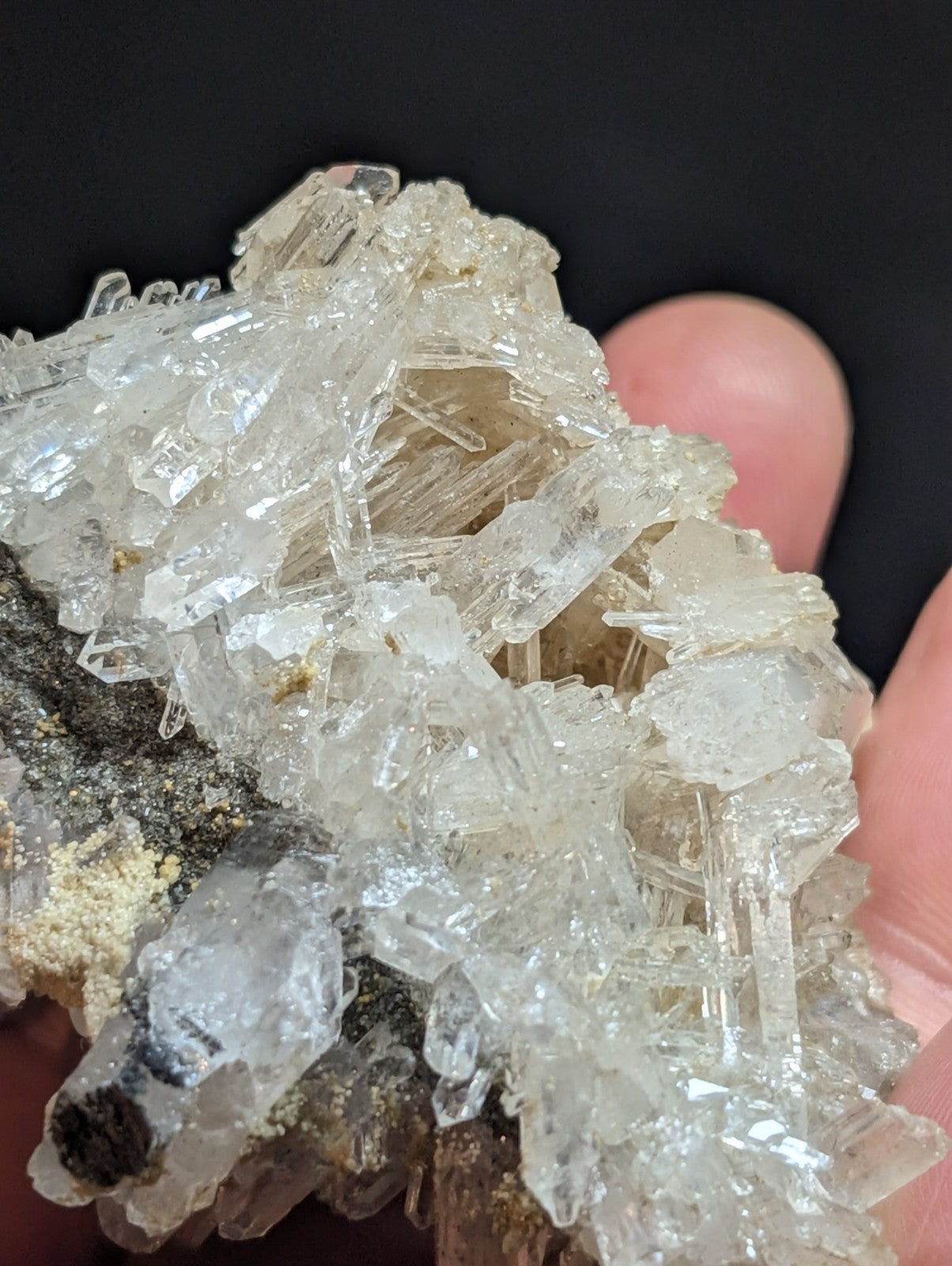 A cluster of translucent, clear quartz crystals with sharp, angular facets and a slightly cloudy appearance.