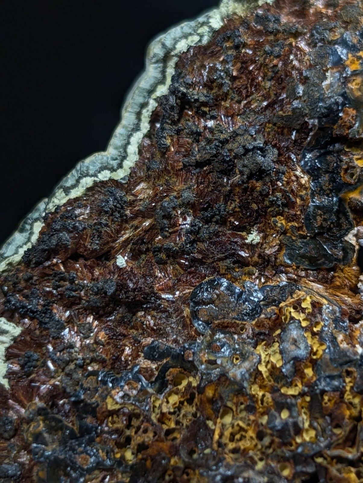 A rugged, multi-toned mineral specimen featuring intricate patterns of rust-brown, black, and yellowish hues with a textured surface.