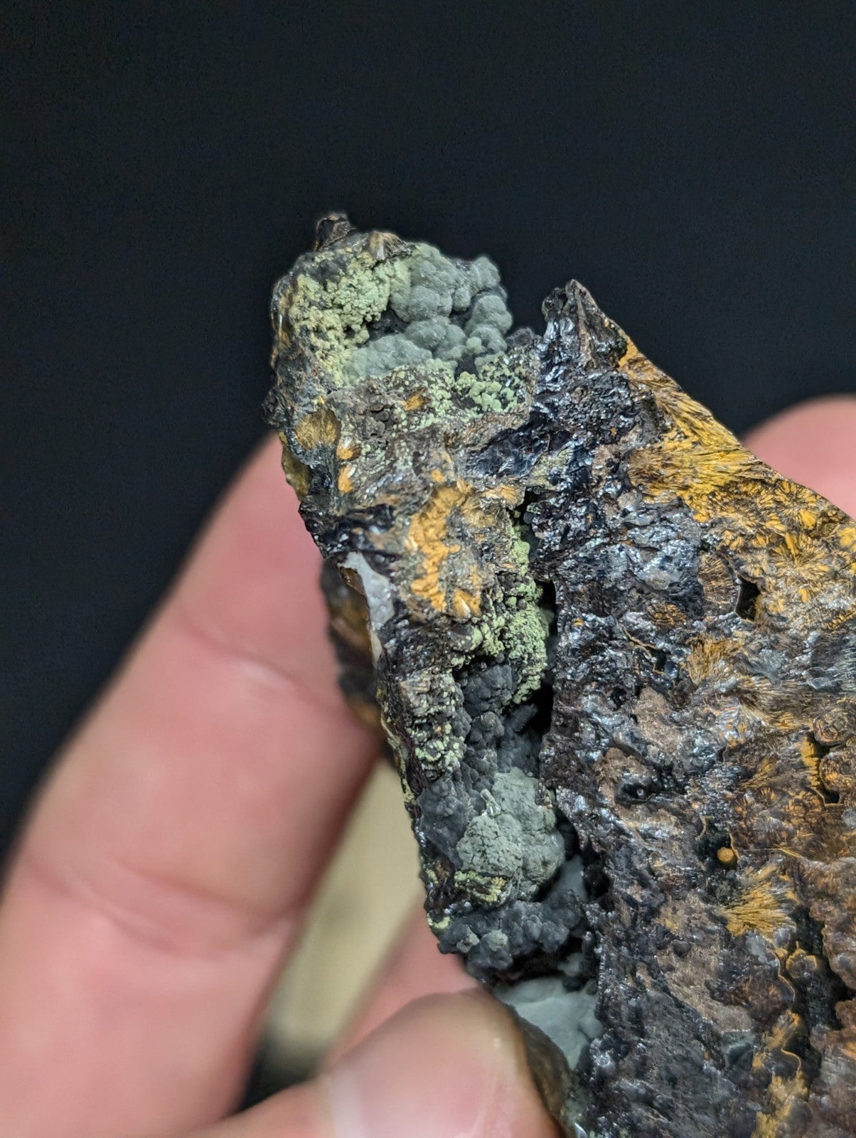 A rugged, irregularly shaped piece of bark with a dark, charred surface and patches of greenish lichen.