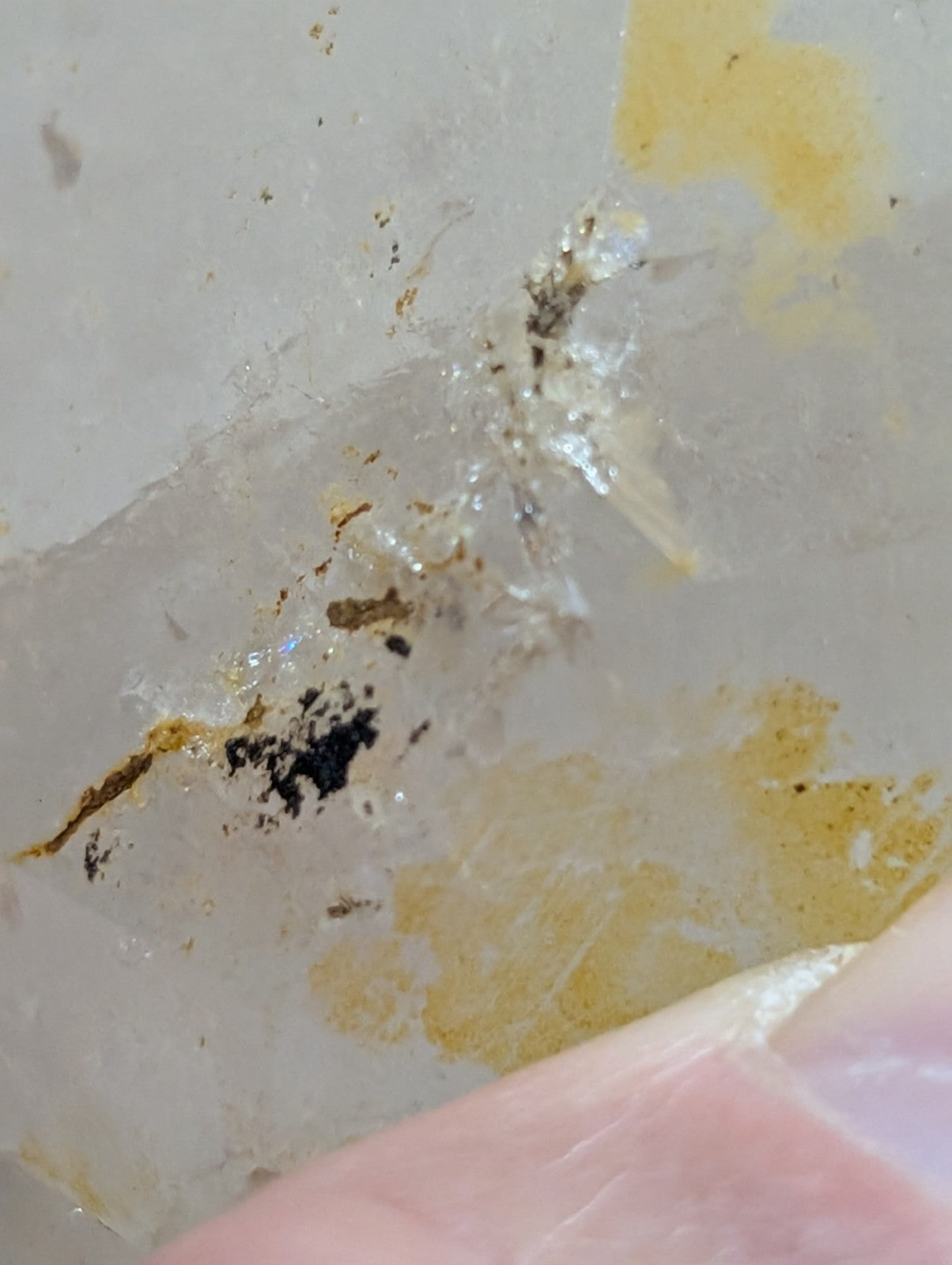 A translucent, pale quartz crystal with subtle yellow and brown inclusions.