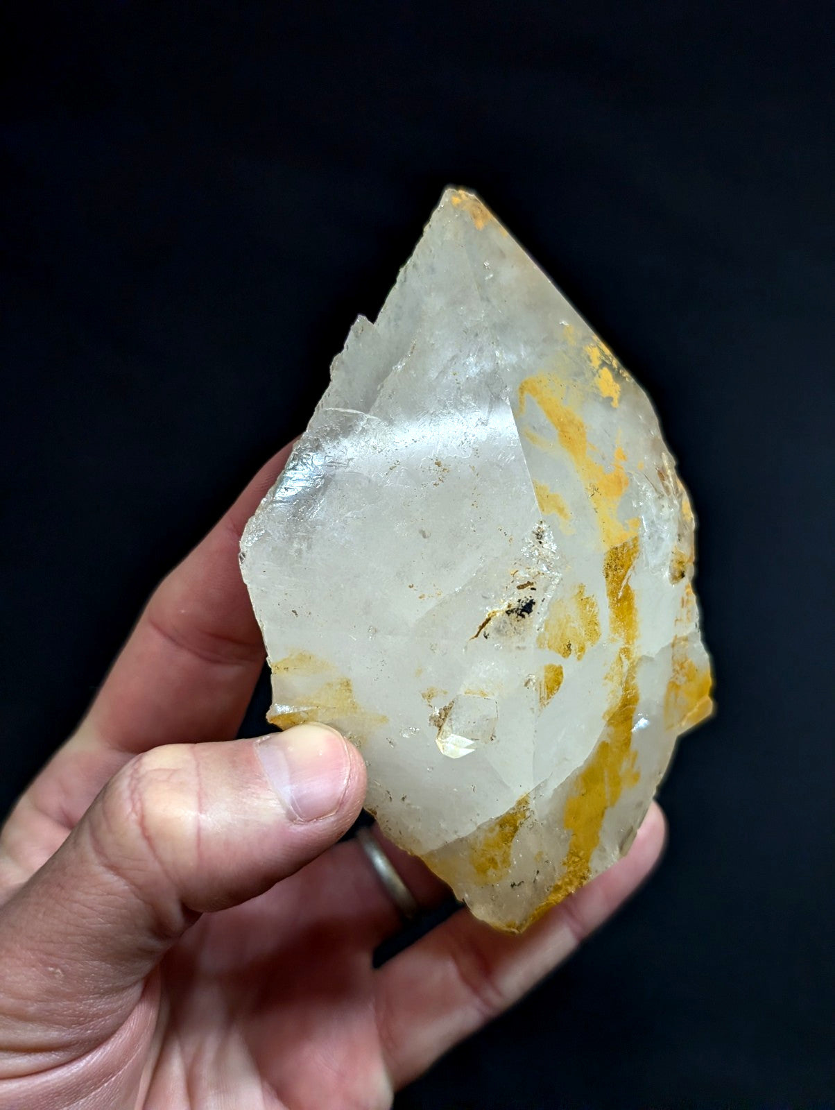 A translucent, irregularly shaped quartz crystal with golden-yellow inclusions and a slightly rough, natural surface.