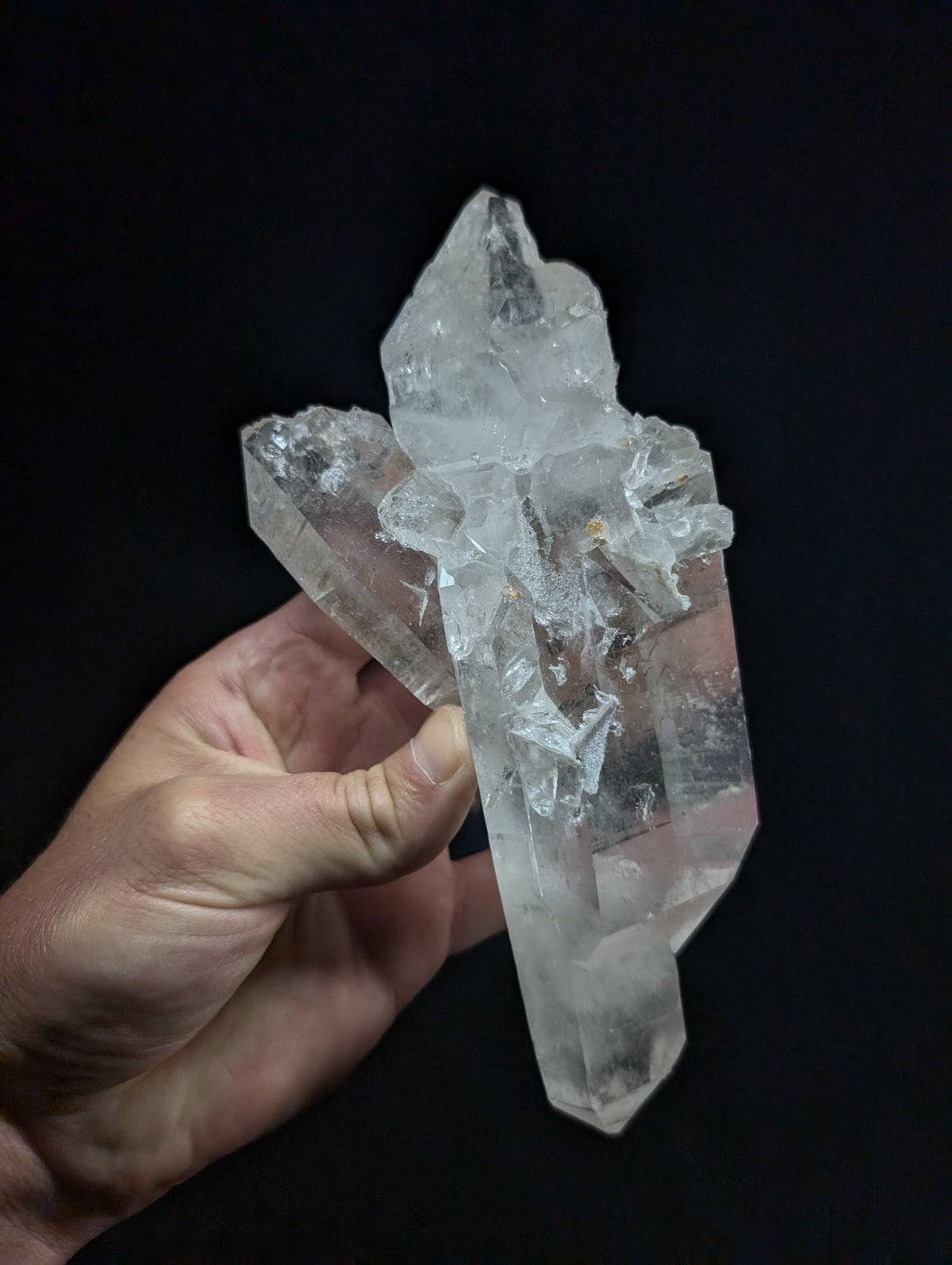 A translucent, clear quartz crystal cluster with sharp, angular facets and a natural, jagged formation.