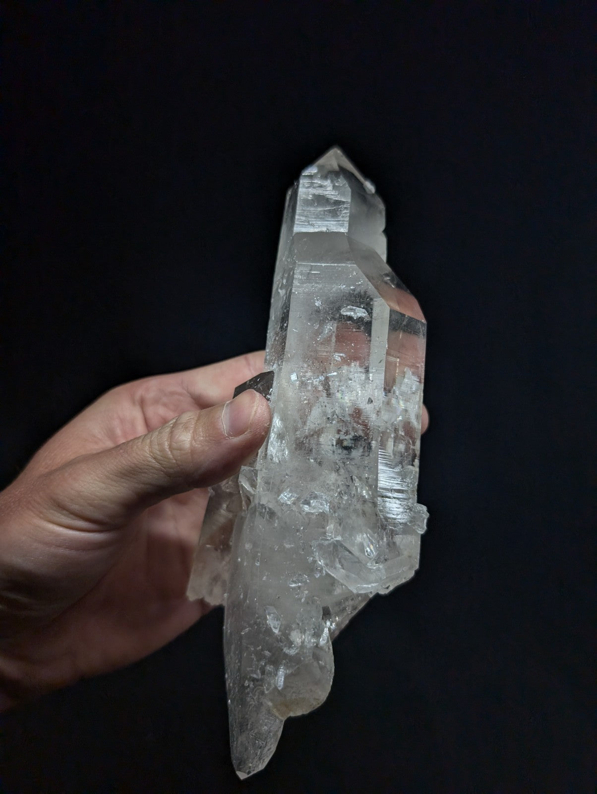A clear, translucent quartz crystal cluster with sharp facets and natural imperfections.