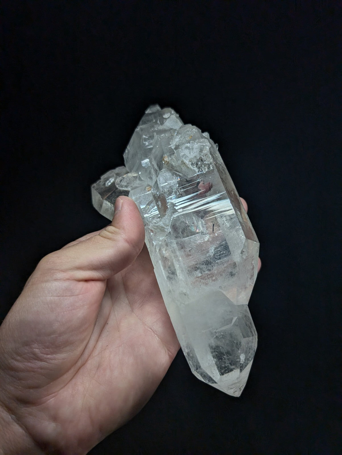 A clear, translucent quartz crystal cluster with sharp facets and natural inclusions.