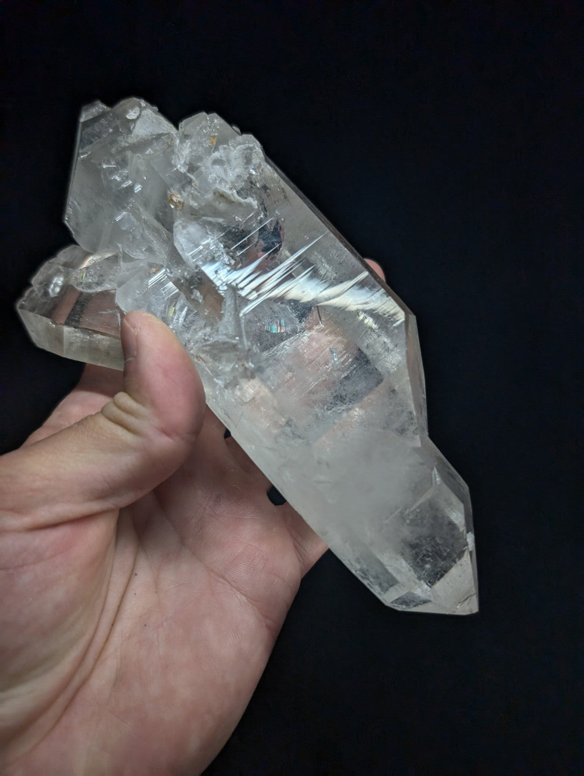 A clear, faceted quartz crystal cluster with a translucent and slightly cloudy appearance.