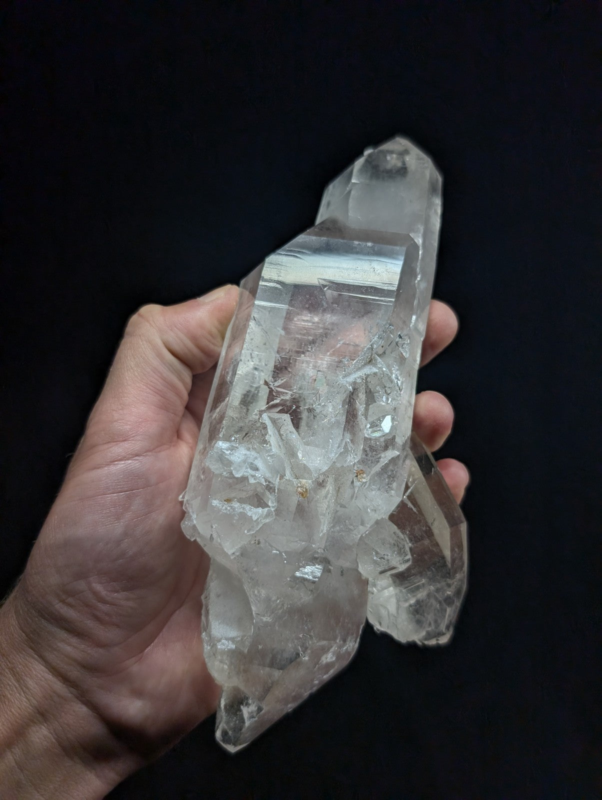 A clear, translucent quartz crystal cluster with sharp facets and natural inclusions.