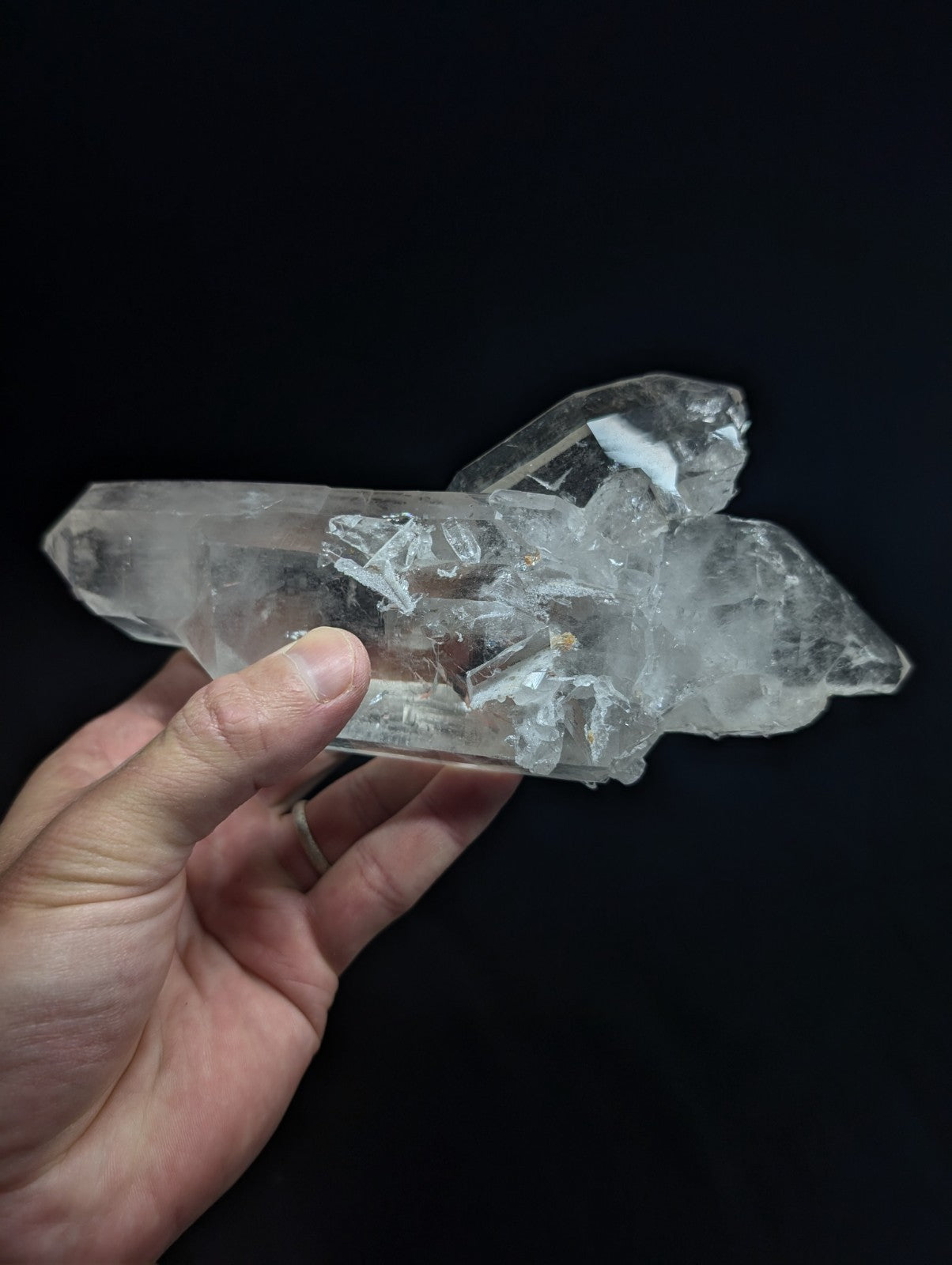 A translucent, clear quartz crystal cluster with sharp facets and natural imperfections.