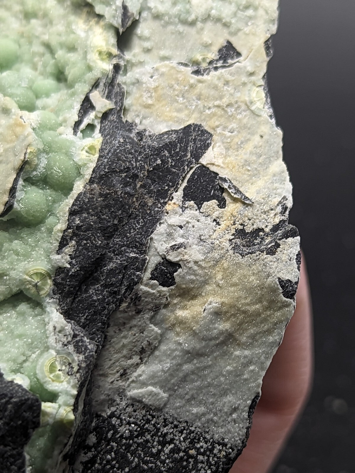 A striking green and black mineral specimen with a textured, crystalline surface.