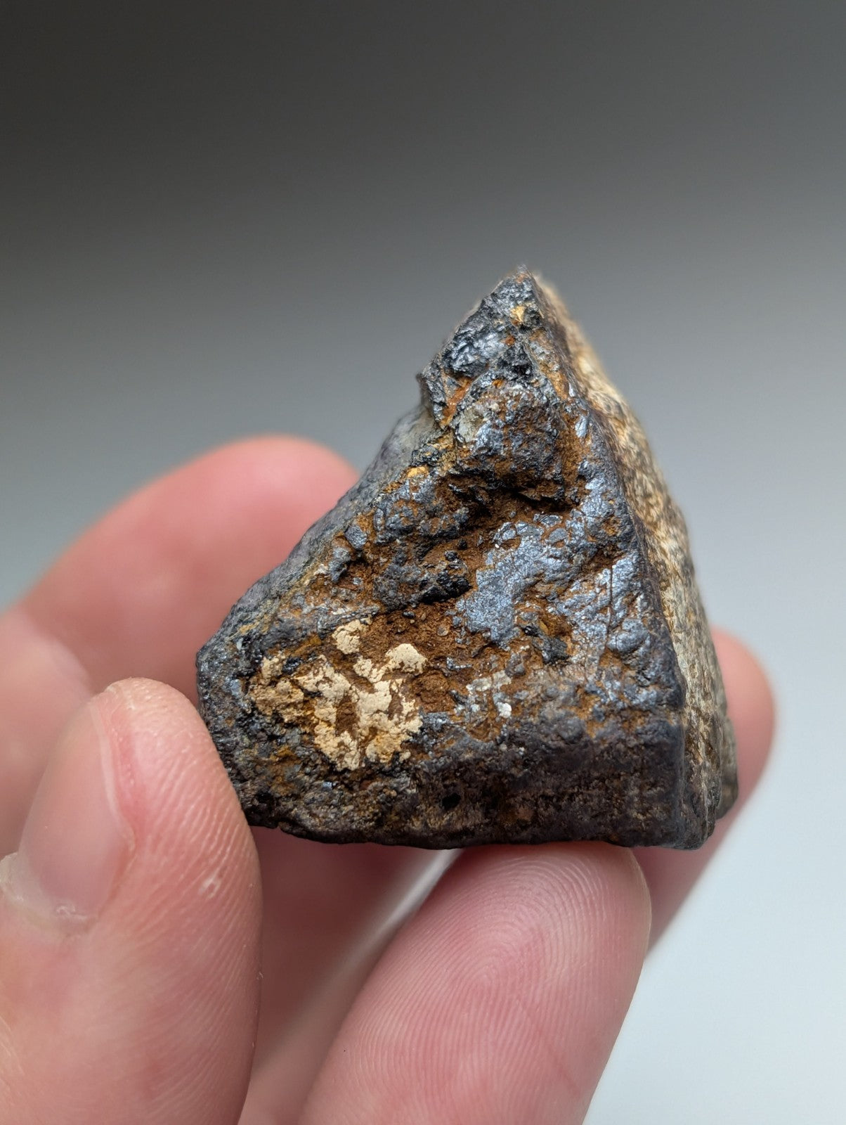 Magnetite lodestone meteorite from magnet cove arkansas with dark metallic surface and rust colored oxidation patches