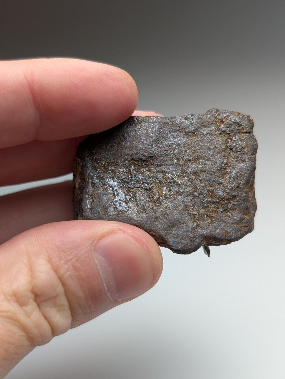 A dark rough-textured magnetite lodestone from Magnet Cove Arkansas with metallic sheen and subtle rust patches