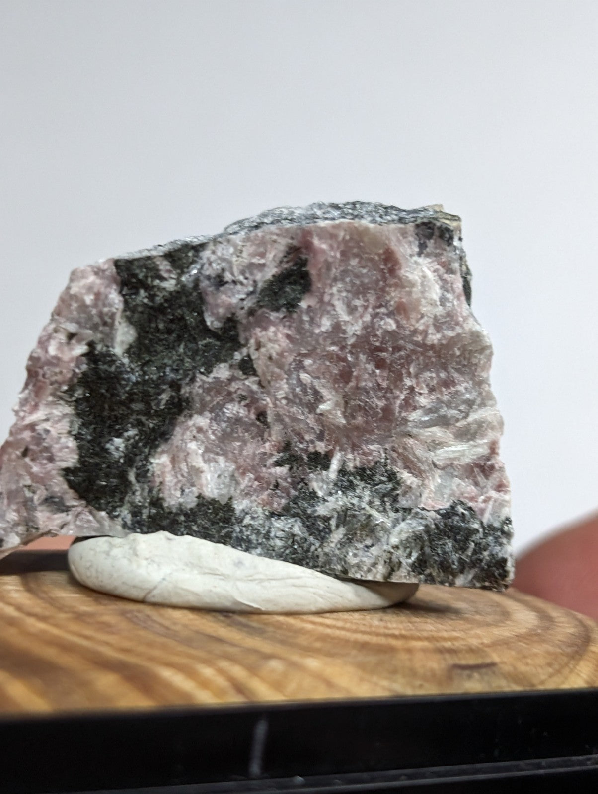 A rugged, irregularly shaped piece of pink and black mineral rock with a rough, crystalline texture.