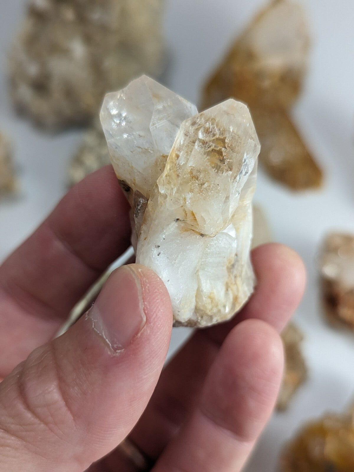 A translucent white quartz crystal cluster with clear, faceted points and subtle golden inclusions.