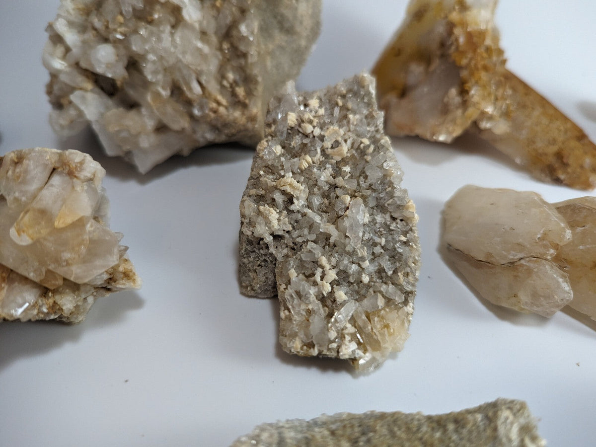 A cluster of translucent, crystalline minerals with a mix of clear and pale yellow hues, showcasing natural geometric formations.