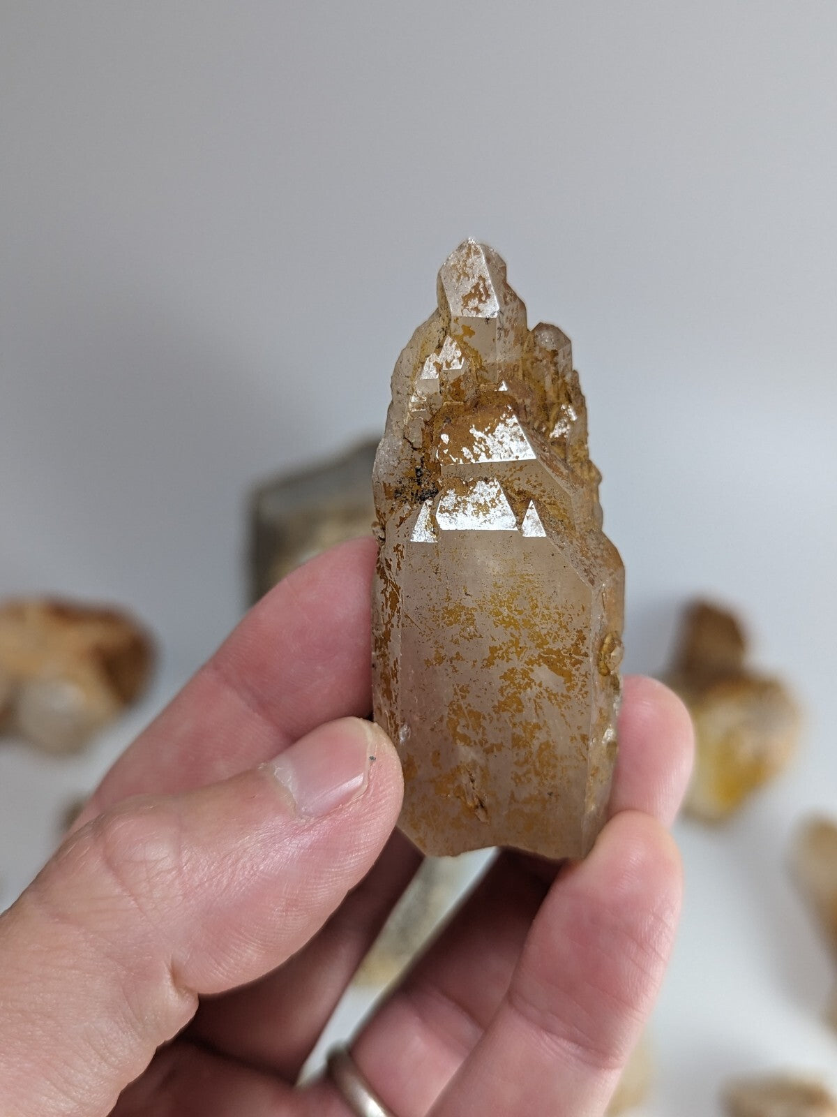 A translucent golden-brown crystal with a pointed, faceted top and natural inclusions.