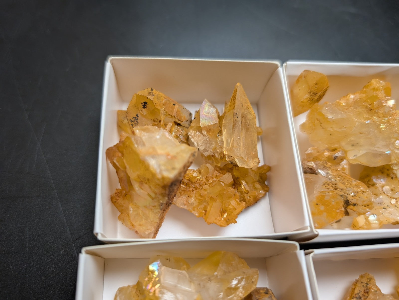 Golden-hued crystal clusters in white boxes.