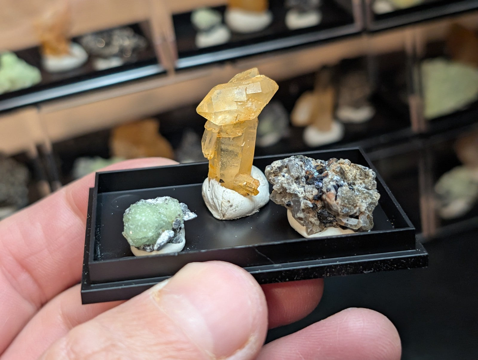 A translucent golden-yellow crystal specimen with a faceted, geometric structure mounted on a white base.