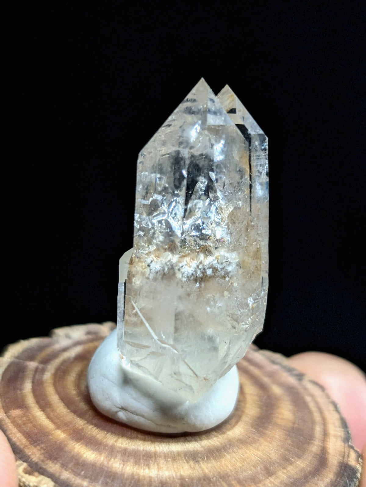 A clear, translucent quartz crystal with a dual-pointed structure and subtle internal inclusions.